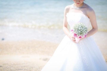 ウェディングドレスを着てカスミソウのブーケを持った新婦
