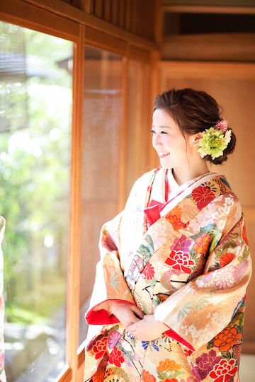 オレンジベージュの色打掛が似合う笑顔の新婦