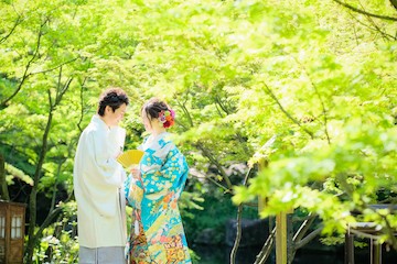 キレイな新緑とブルーの色打掛を来た新婦と白の紋付姿の新郎