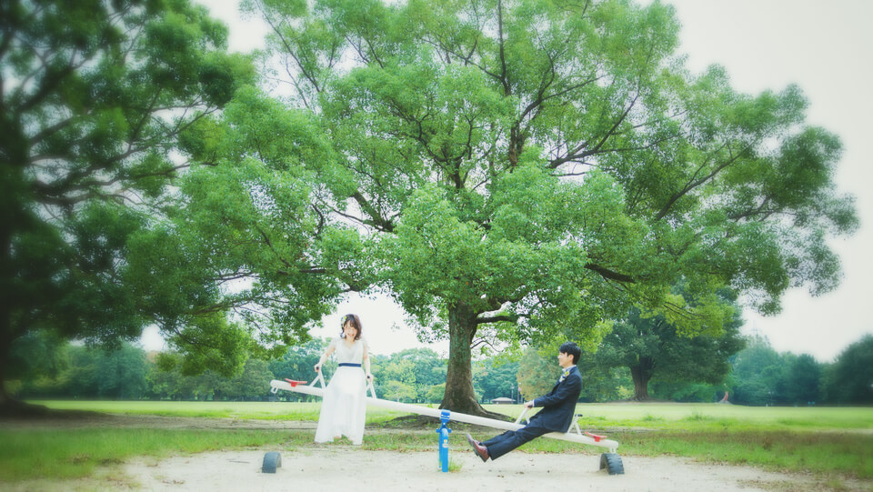 笑顔でシーソーに乗る新郎新婦