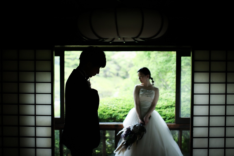 障子を額縁のように使い、庭を背にして立つウェディングドレスの花嫁と新郎のシルエット。洋装のフォトウェディング
