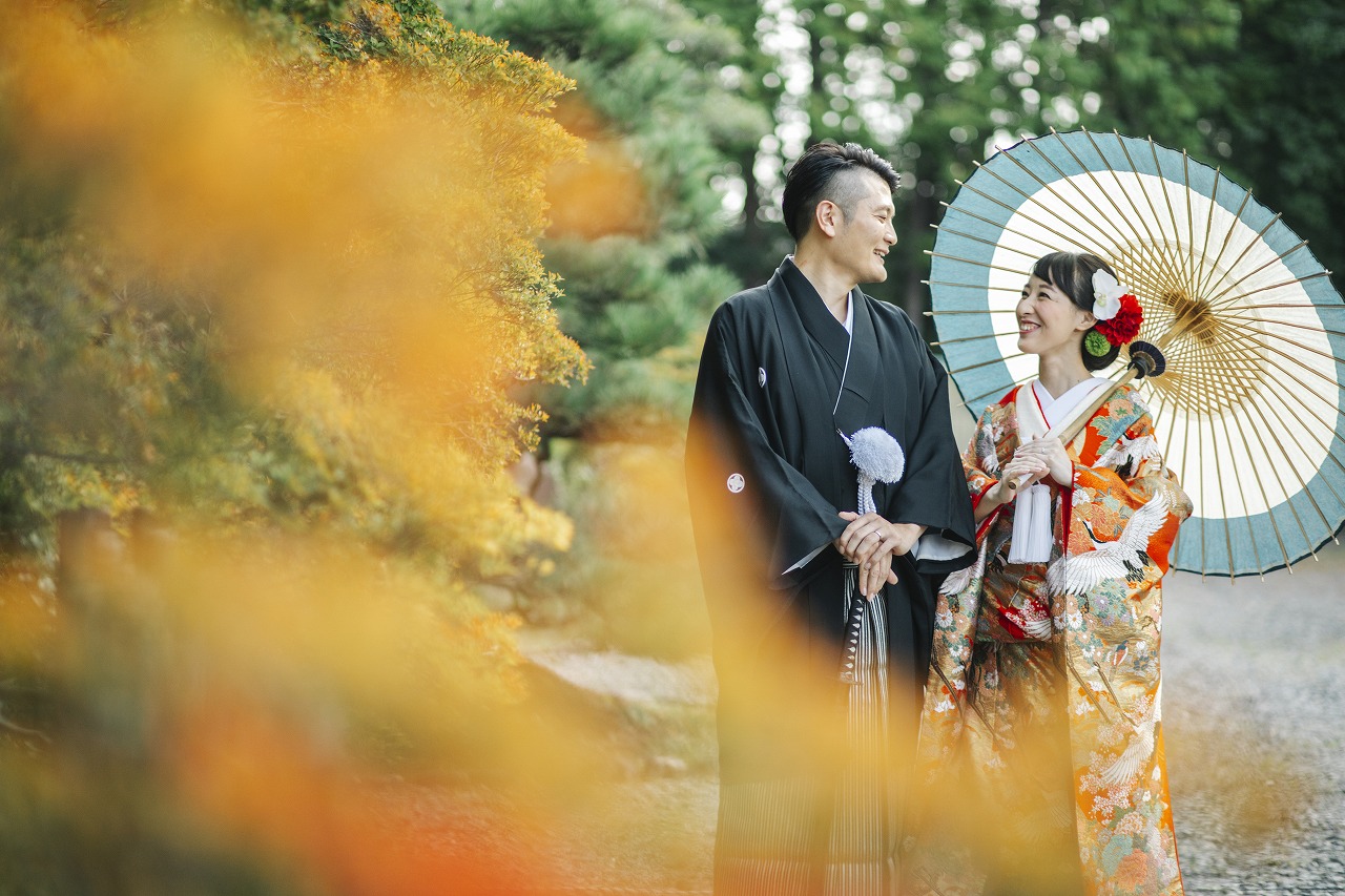 色づく葉っぱと微笑み合う新郎新婦