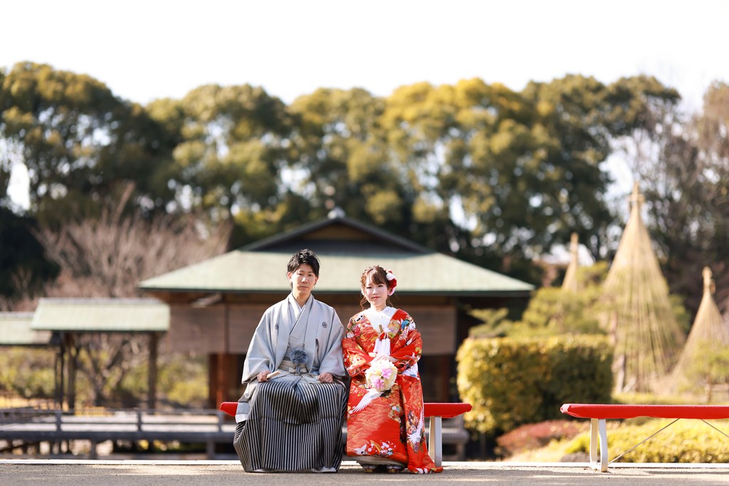 雪吊りを施した松の向こうに建つ清羽亭と色打掛の花嫁。冬の白鳥庭園で撮る和装ロケーションフォト