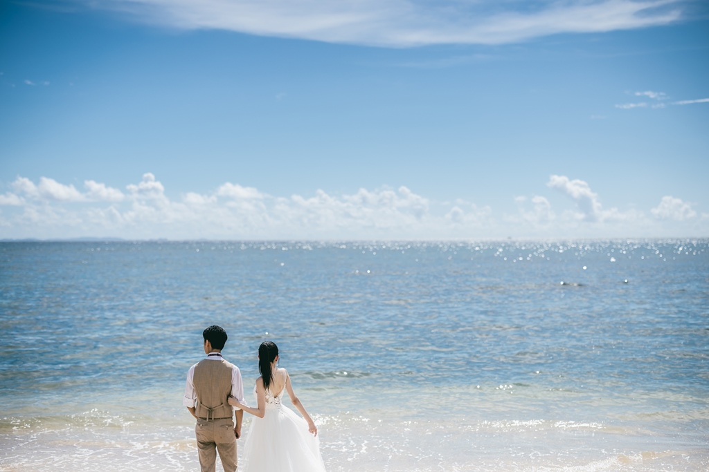 沖縄の広い海と新郎新婦