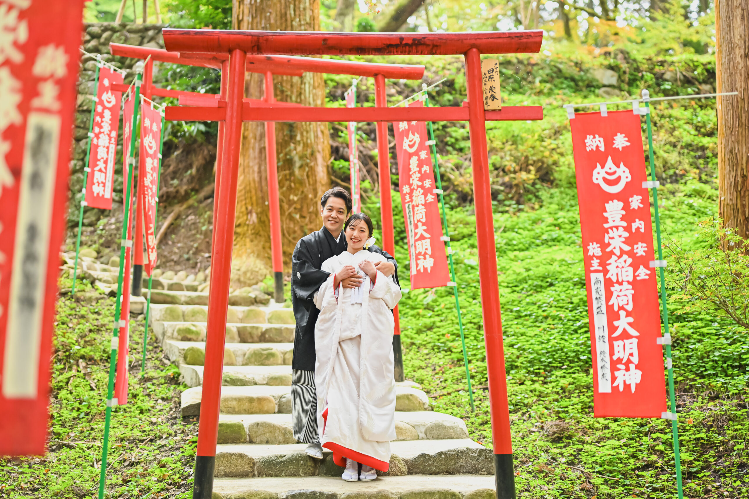 三州足助稲荷の朱色の鳥居が続く参道を上る白無垢の花嫁と紋付袴の新郎。香嵐渓の和装前撮り