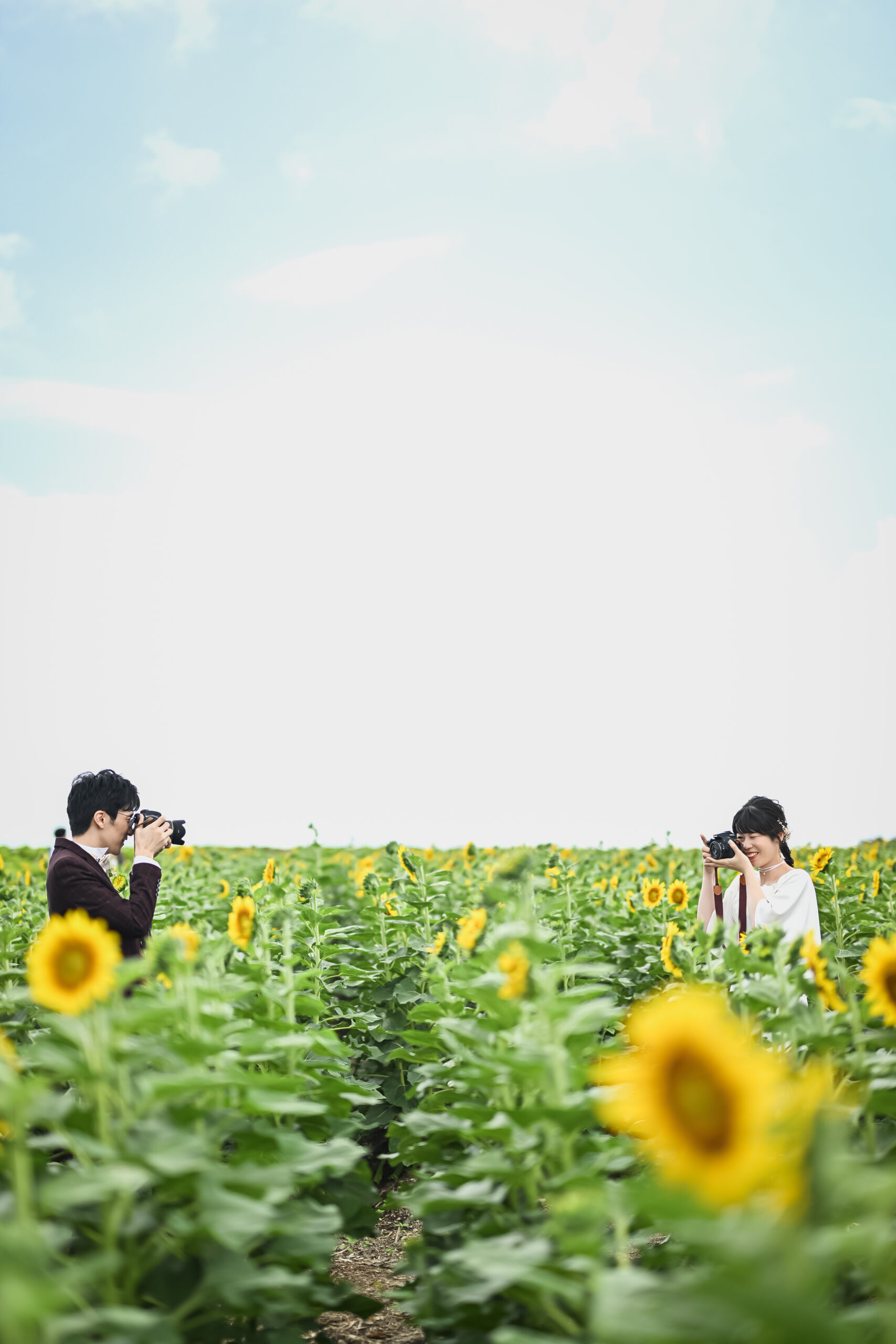 花ひろばでカメラマンがカップルを撮影するメイキング風景