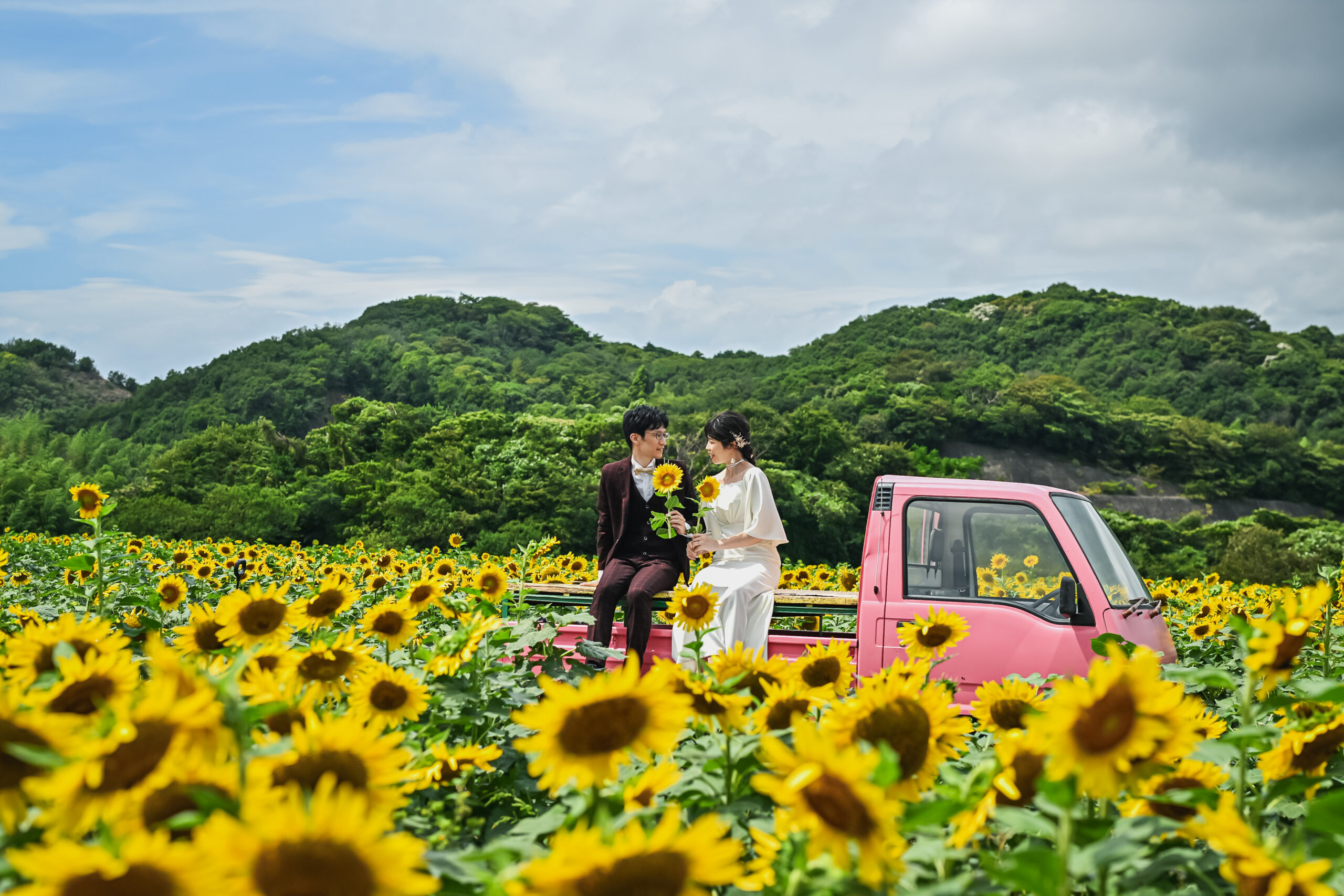 ひまわり畑でカラードレスを着た花嫁