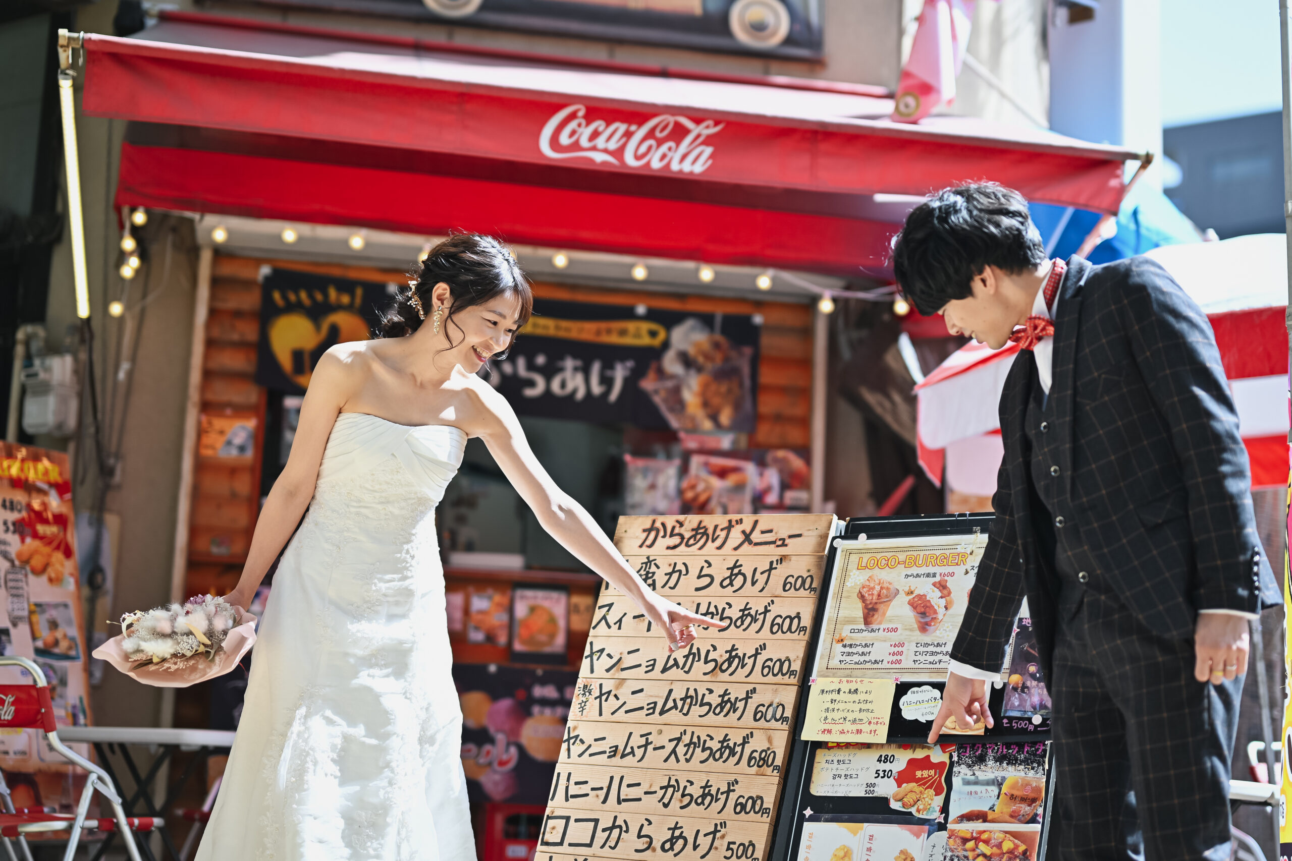 名古屋の商店街を笑顔で歩くウェディングドレスのカップル