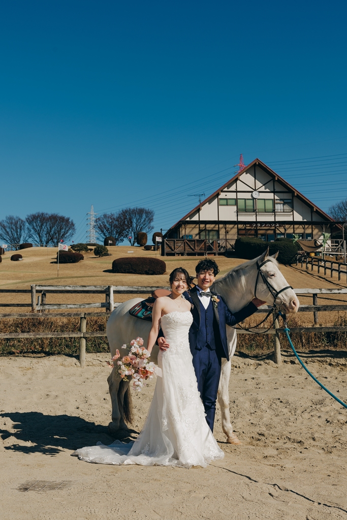 馬の手綱を引いて並んで歩く新郎新婦