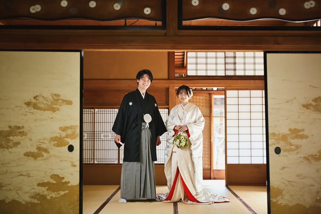 東山荘の縁側でたたずむ白無垢姿の花嫁と新郎