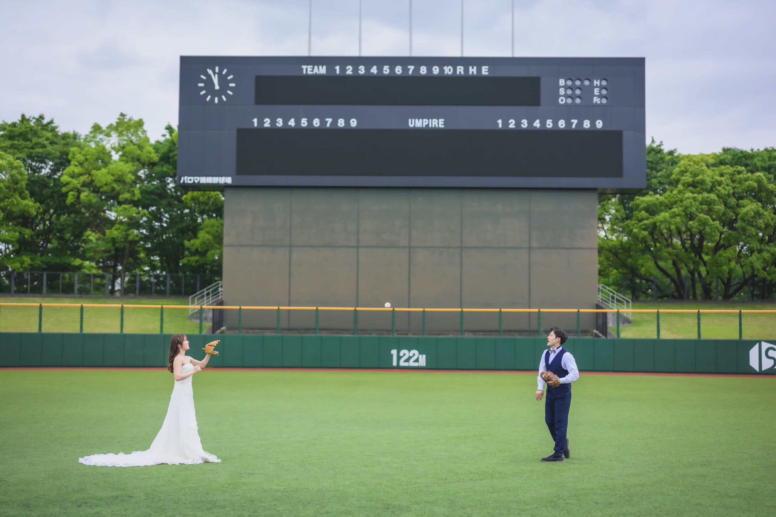 スタジアムスタンドでウェディングドレス姿のカップル