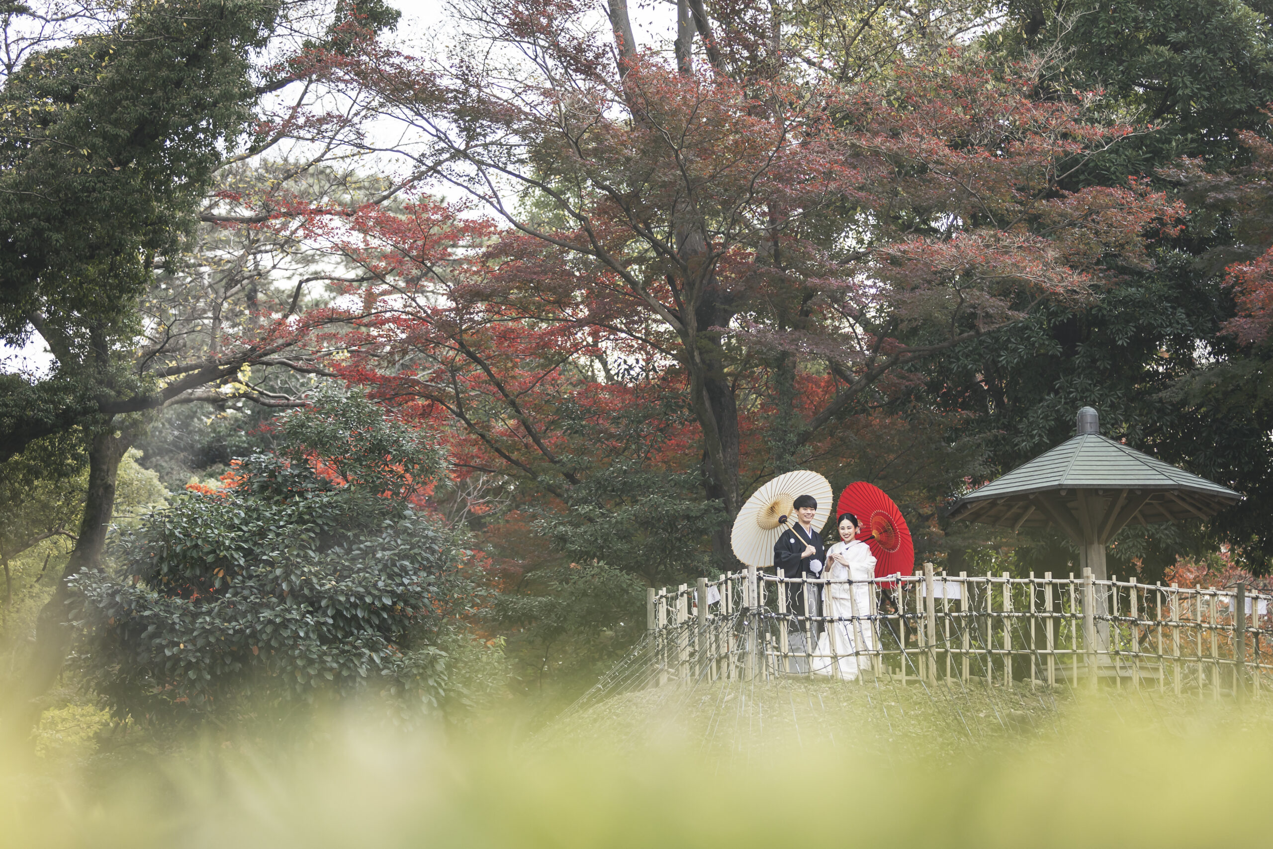 紅葉に彩られた岡崎城の石垣を背景にした和装前撮り写真
