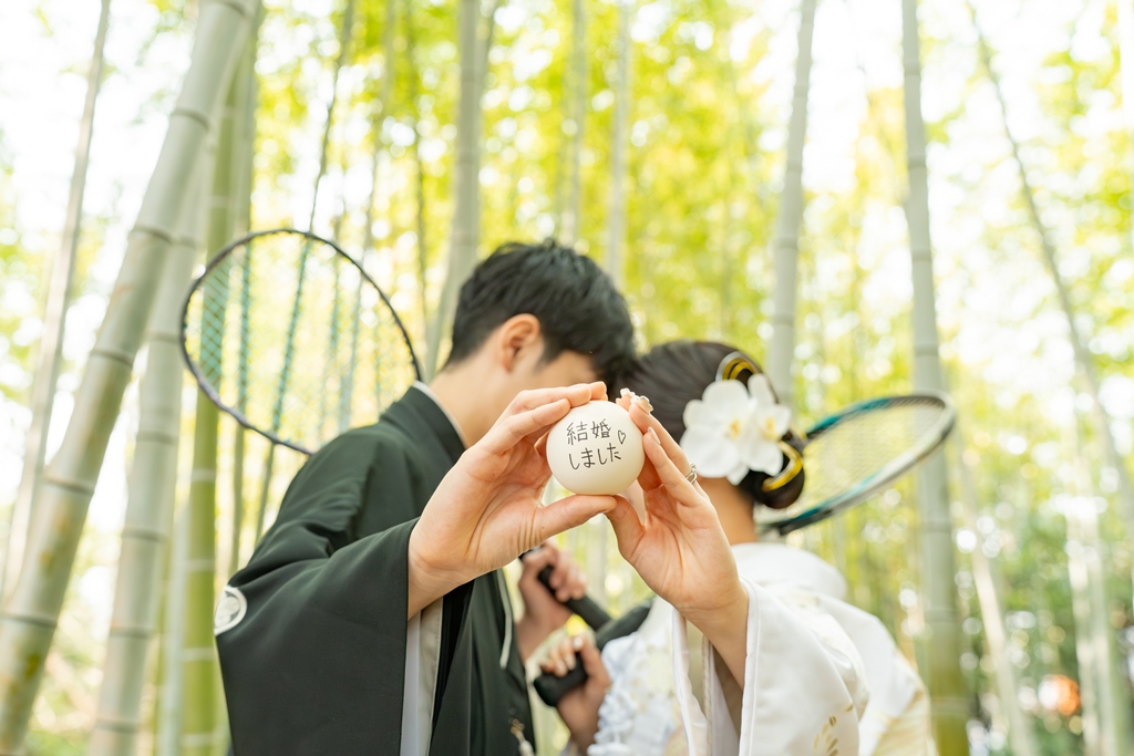 和装の花嫁と新郎が思い出のアイテムを持って楽しそうに撮影している写真
