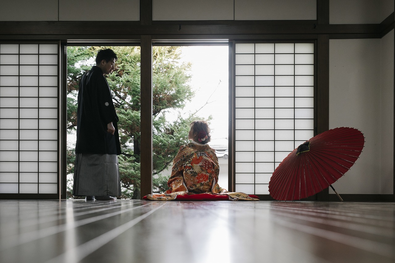 清州城天守閣を背景に和装で立つ新郎新婦