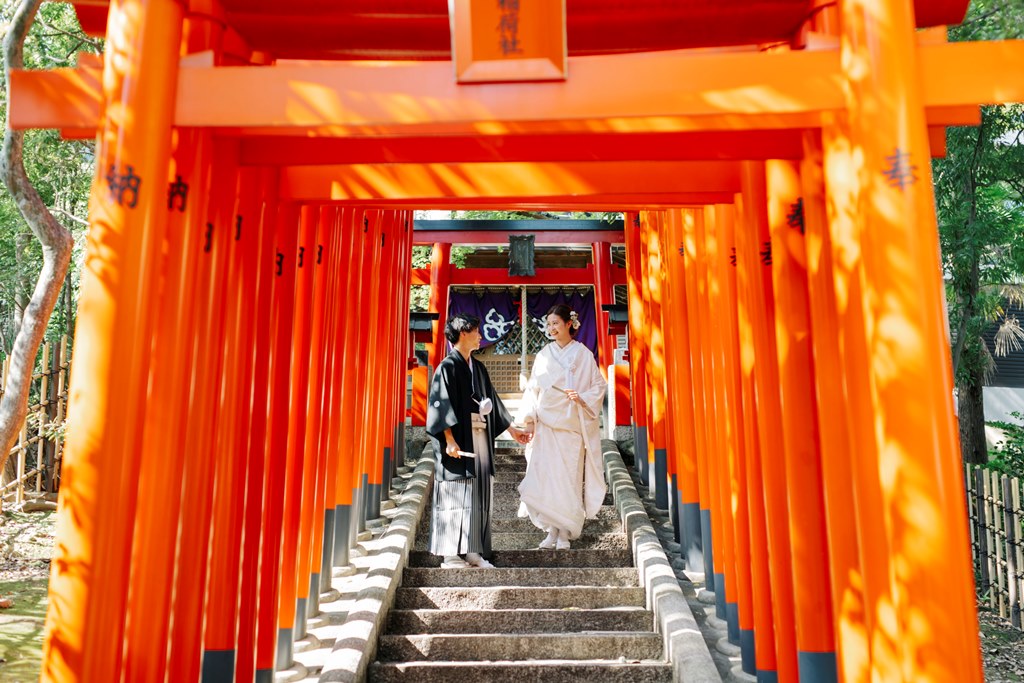 揚輝荘の和と洋が調和した建築を背景にした和装カップル