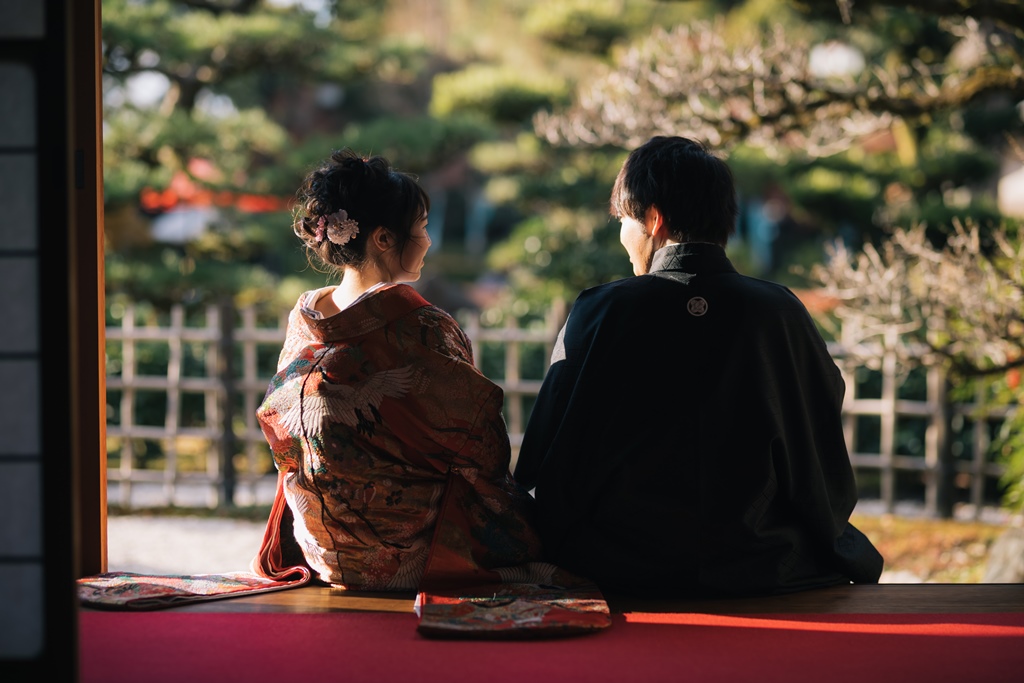 夕暮れ時に紅葉と共に佇む新郎新婦