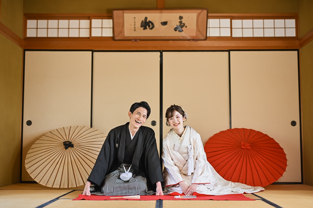 鮮やかな色打掛を纏って岡崎城で撮影するカップルの写真