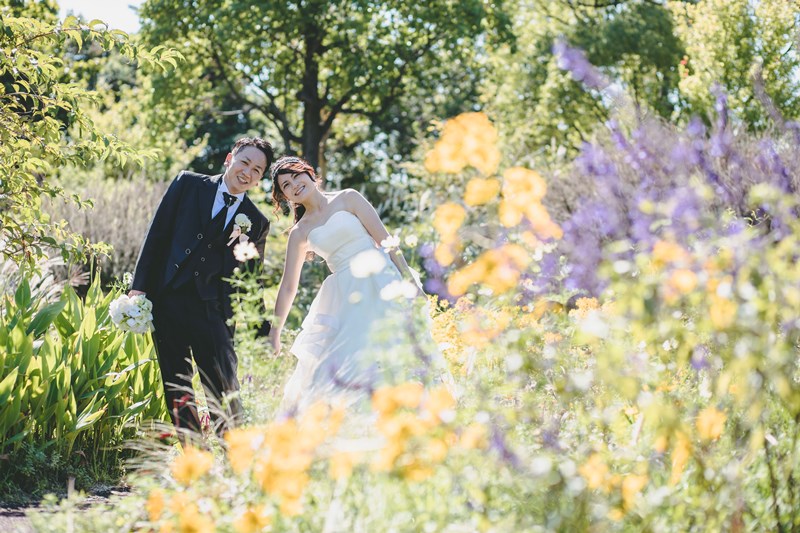 メグラスガーデンの色とりどりの花々を背景にした洋装カップル