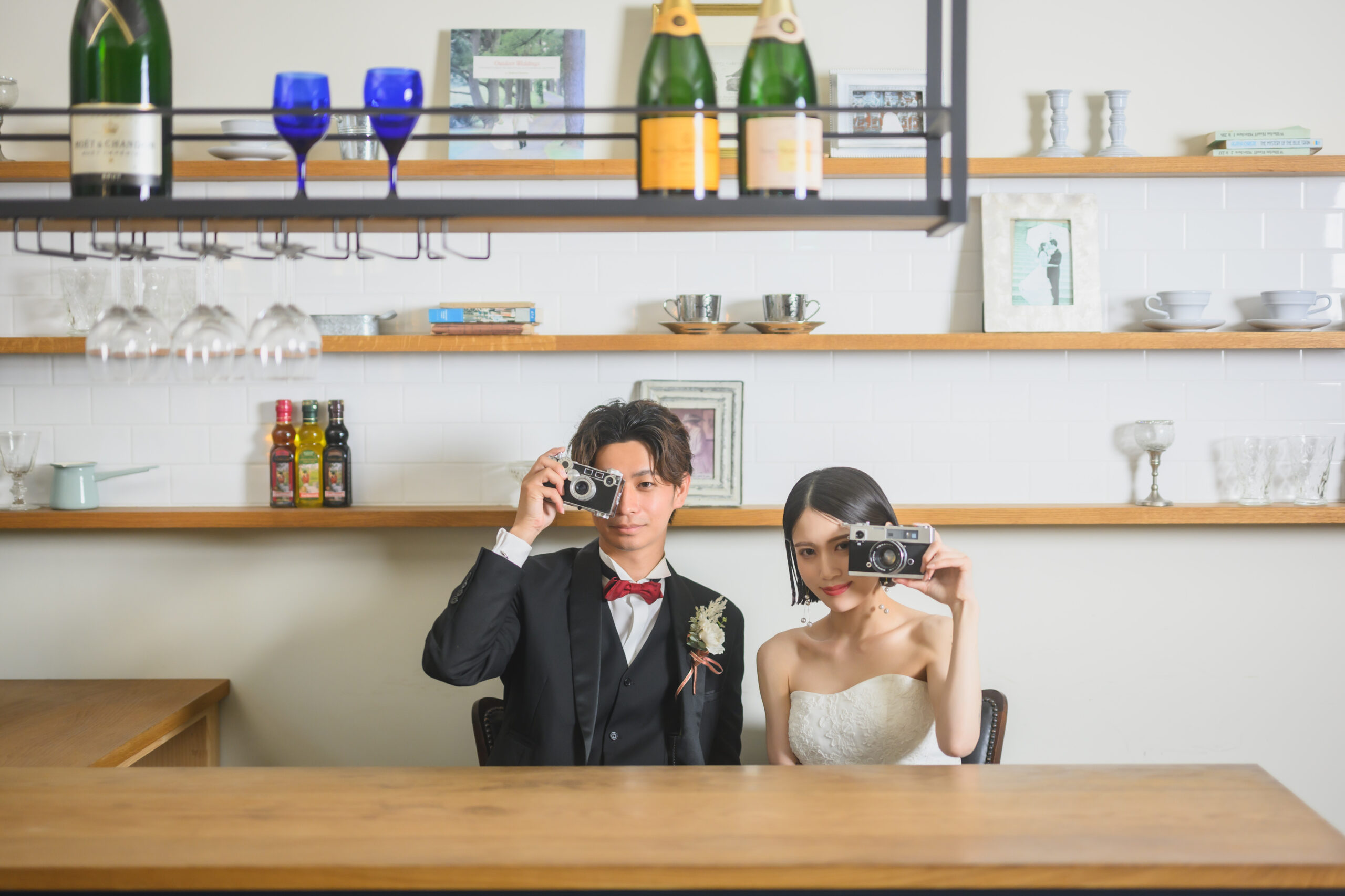 THE SKY WEDDINGのスタジオで白いドレスを着て笑顔で撮影する花嫁と新郎