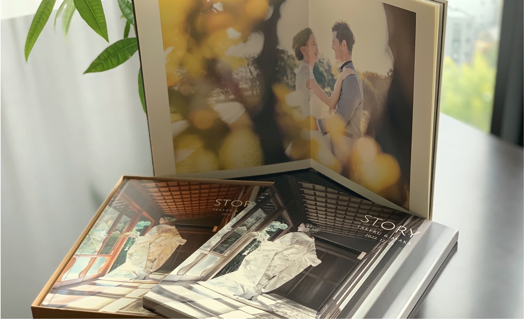 完成したウェディングアルバムが届いて喜ぶカップルの写真
