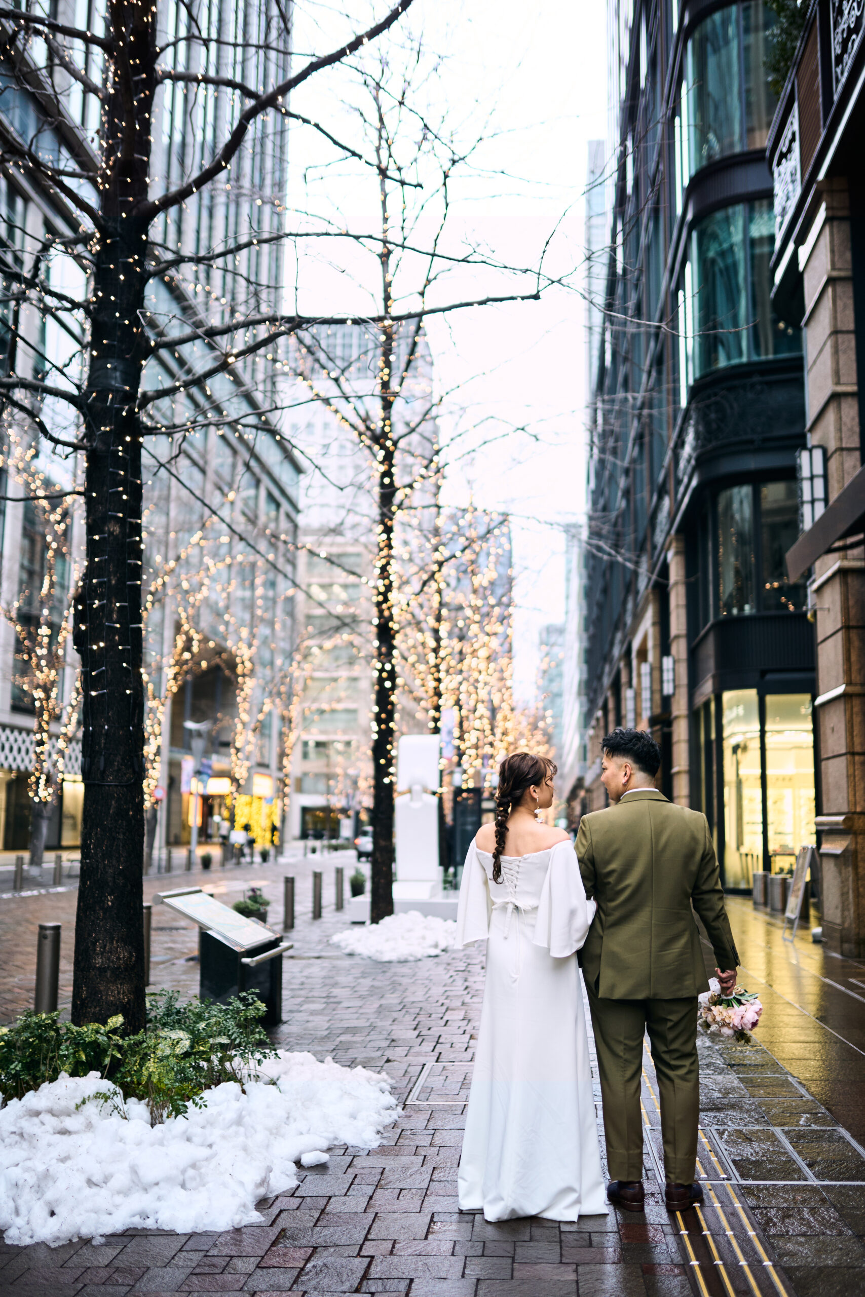 雪景色を背景に撮影する新郎新婦