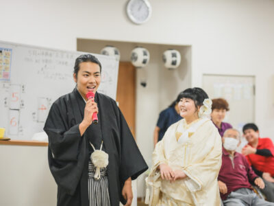 デイサービスを背景にした新郎新婦の記念写真