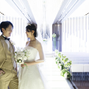 まっすぐ延びるバージンロードを背に、入口で見つめ合う新郎新婦。ラグナヴェール名古屋のチャペルで撮るナチュラルなフォトウェディング