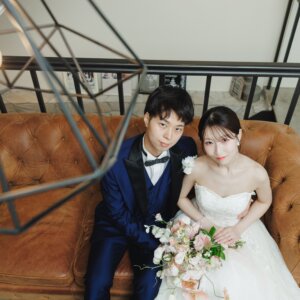 革張りのソファに並んで座り、見上げてほほえむ新郎新婦を真上から写した一枚。ペンダントライトが映えるおしゃれなスタジオフォト
