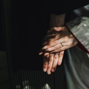 黒紋付袴の袖に重ねた新郎新婦の手と結婚指輪のアップ。名古屋のスタジオで撮る和装前撮りの指輪のクローズアップ