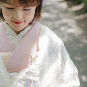 白い花の髪飾りを付けて目を伏せる白無垢の花嫁のアップ。和装前撮りのヘアアレンジのクローズアップ