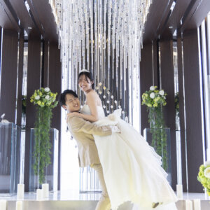 祭壇の前で花嫁を抱き上げてはしゃぐ新郎と、笑顔でしがみつくウェディングドレスの花嫁。名古屋のチャペルで撮る楽しい結婚写真