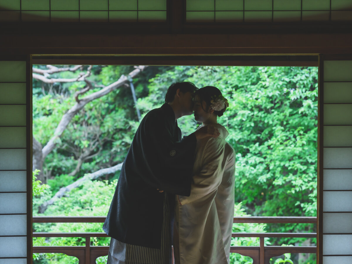 障子の枠の中で額を寄せ合う黒紋付袴の新郎と色打掛の花嫁のシルエット。日本家屋で撮る和装前撮り