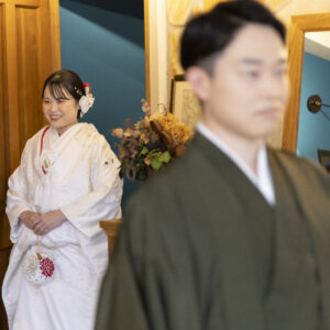 ドアの奥から、背を向けて待つ新郎の元へ歩み寄る白無垢の花嫁。名古屋のスタジオで撮るファーストミートの和装前撮り