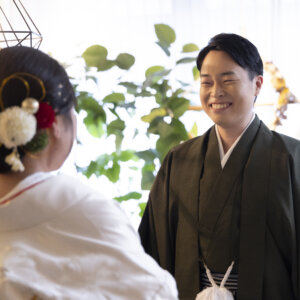 振り返った新郎と笑顔で向き合う、白無垢の花嫁の後ろ姿。和の髪飾りが映えるファーストミートのフォトウェディング