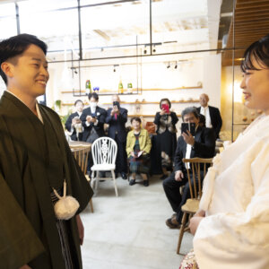 ご家族が見守るスタジオで、振り向いた新郎と見つめ合う白無垢の花嫁。家族と一緒に楽しむ名古屋のスタジオでの和装前撮り