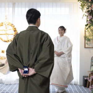 リングボックスを背中に隠して花嫁と向き合う羽織袴の新郎。サプライズのプロポーズを再現した名古屋のスタジオフォト