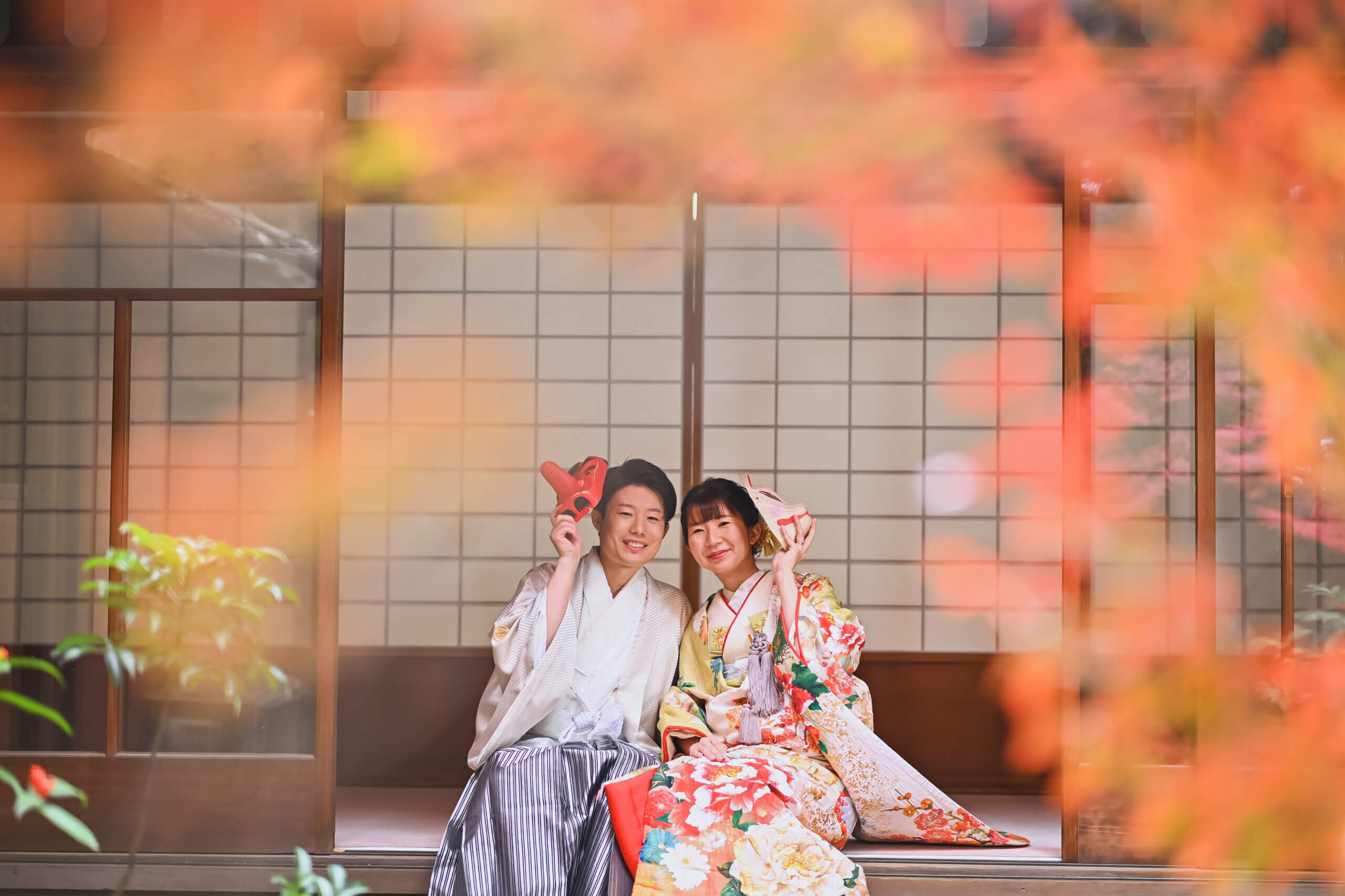 落ち葉の中で微笑む新郎新婦の写真